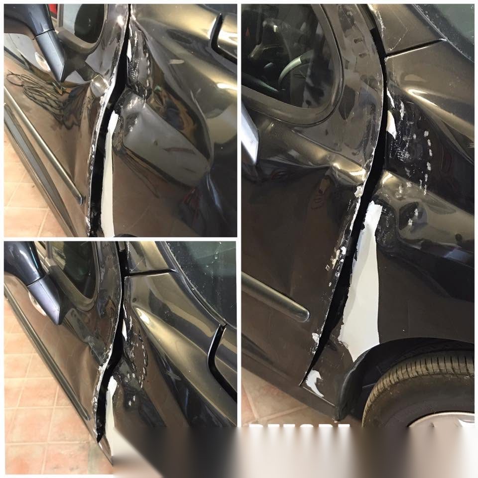 Black Peugeot with the rear door and wing torn open and buckled after an accident